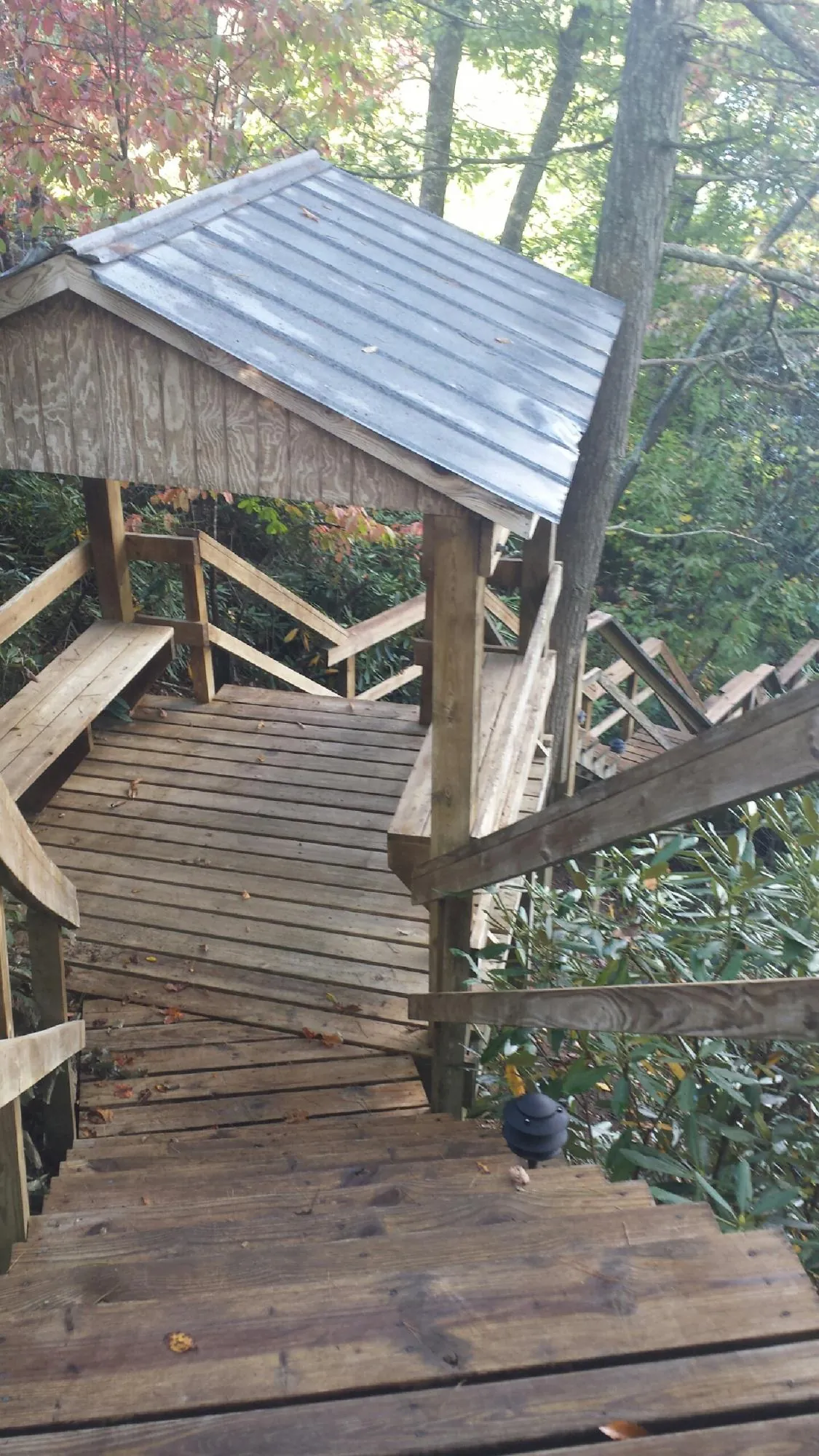 Metal roofed shelter over wooden steps on a wooded walkway — Skylight Repair & Installation work by our crew in Universal City